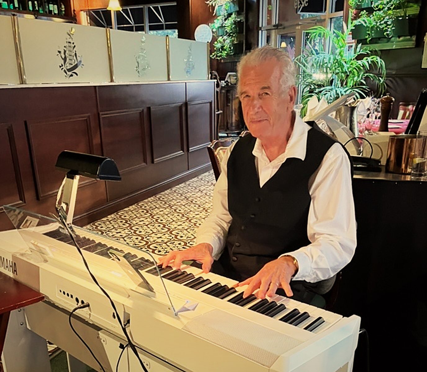 Alan Souza playing piano in the dining room at Pascone's